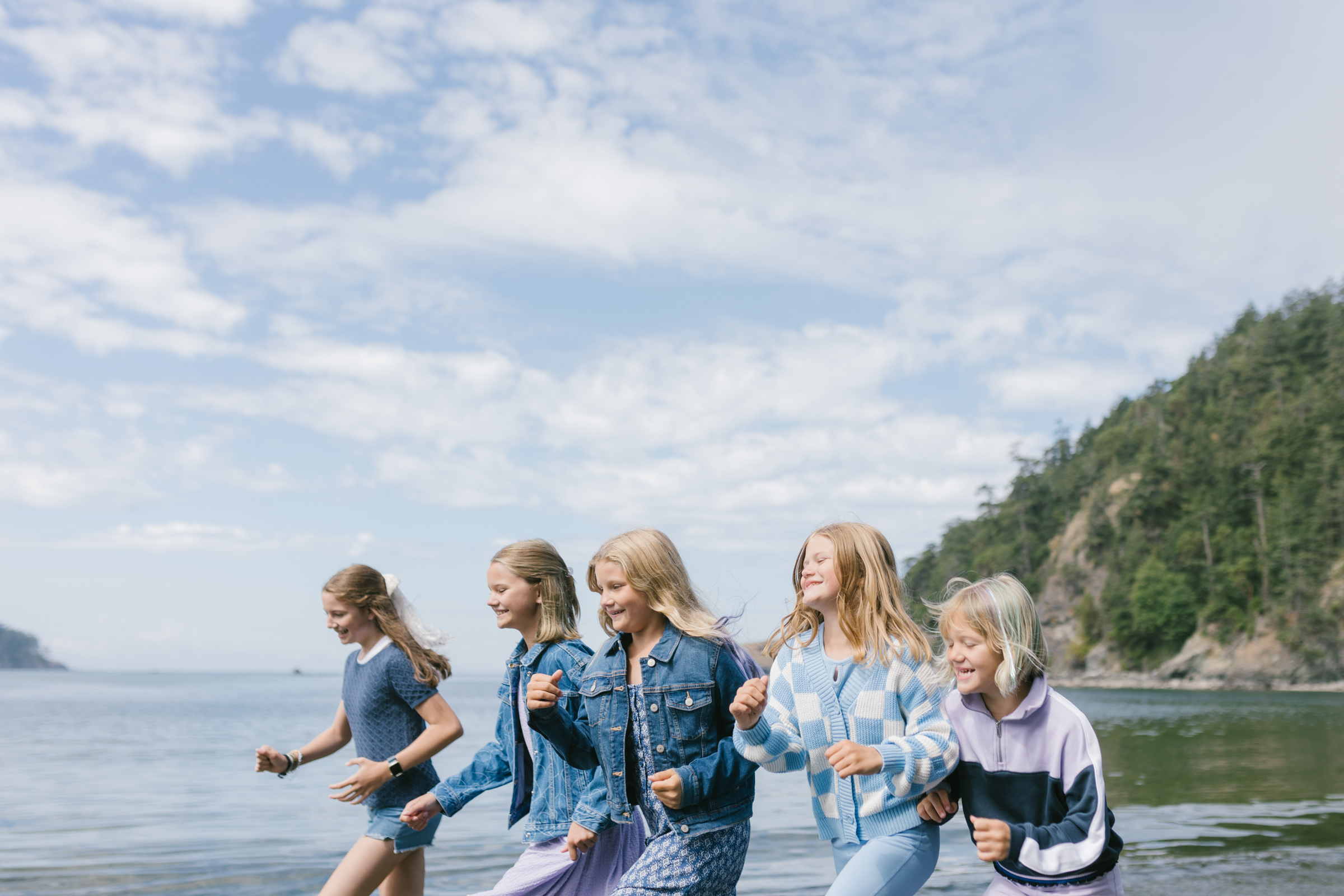 Three sisters walk along the beach together during their family photos at Deception Pass.